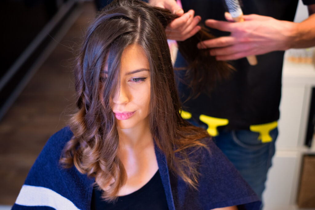 Stylist finishing a client’s haircut and hairstyle at KL Beauty Salon in San Jose