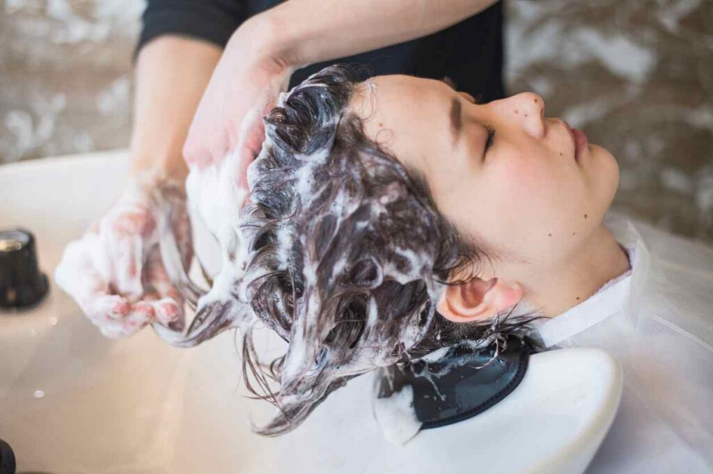 Salon professional shampooing a client’s hair at KL Beauty Salon in San Jose